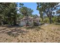 Single-story home with a welcoming front porch, nestled among mature trees and natural landscape at 11101 Corlett Rd, Riverview, FL 33578
