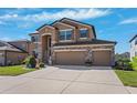 Beautiful two-story home with well-maintained landscaping, stone detailing, and a convenient three-car garage at 18774 Malinche Loop, Spring Hill, FL 34610