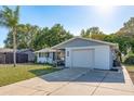 Single-story home featuring a white exterior, one-car garage, and palm tree in the front yard at 10137 Oleander Dr, Port Richey, FL 34668