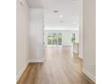 Bright hallway boasts wood-look floors leading to an open living area with sliding glass doors to the outside at 10708 Oak Bend Dr, Parrish, FL 34219