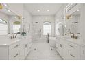 Luxurious main bathroom with a soaking tub, glass enclosed shower, and dual vanities with brass fixtures at 1220 Darlington Oak Ne Cir, St Petersburg, FL 33703