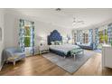 Bright main bedroom with hardwood floors, stylish furniture, and an abundance of natural light from bay windows at 1220 Darlington Oak Ne Cir, St Petersburg, FL 33703