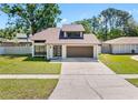 Well maintained home with a clean lawn, driveway, modern style door and a two car garage at 15307 Summerwind Dr, Tampa, FL 33624