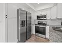 Modern kitchen featuring stainless steel appliances and sleek white cabinetry at 16512 Brigadoon Dr, Tampa, FL 33618