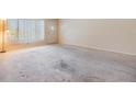 Spacious living room featuring a large window providing natural light, and neutral carpet and wall colors at 2310 Denmark St # 30, Clearwater, FL 33763