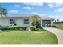 Welcoming one-story home showcasing tidy landscaping and a convenient covered carport at 2313 Grenoble Pl # 2313, Sun City Center, FL 33573