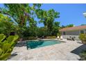 Backyard pool surrounded by stone patio and lush landscaping, creating a private outdoor oasis at 246 20Th Ne Ave, St Petersburg, FL 33704