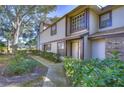 Inviting townhome featuring lush landscaping, tan siding, and brick accents at 2663 Sequoia Ter # 2663, Palm Harbor, FL 34683