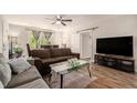 Open living room with hardwood floors, ceiling fan, and natural light from the exterior at 3006 E Henry Ave, Tampa, FL 33610