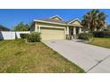 Single-Gathering home featuring well-kept lawn, concrete driveway, and an attached garage at 3015 Azalea Blossom Dr, Plant City, FL 33567