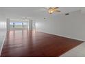 Spacious living room with gleaming hardwood floors, ceiling fans, and expansive windows offering stunning water views at 5980 Shore S Blvd # 312, Gulfport, FL 33707