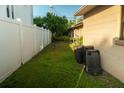 A narrow side yard with lush green grass and a white fence, providing privacy and space at 631 Luzon Ave, Tampa, FL 33606