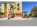 Beautiful yellow townhome with red garage doors and lush tropical landscaping at 6412 Mayra Shores Ln, Apollo Beach, FL 33572