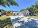 Inviting single-story home with landscaped front yard, long driveway, and decorative front door at 6811 S Himes Ave, Tampa, FL 33611
