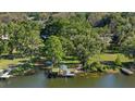 An aerial view of the house on the water with boat dock in the backyard, and lush greenery surrounding the property at 8020 Sharon Dr, Tampa, FL 33617