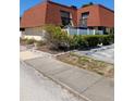 Exterior view of a two-story townhome with a red tile roof and a white fence at 8119 Oak Trace Way # C, Tampa, FL 33634