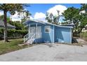 Side view of charming single-story home with concrete driveway and lush green lawn at 8624 N Semmes St, Tampa, FL 33604