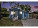 Charming blue single-story home with a well-manicured lawn and a concrete driveway at dusk at 8624 N Semmes St, Tampa, FL 33604