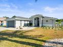Single Gathering home with two-car garage, updated paint, arched entrance and manicured front lawn at 8702 Pinafore Dr, New Port Richey, FL 34653