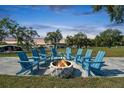 An inviting outdoor gathering space features a stone fire pit surrounded by comfortable Adirondack chairs at 10029 Wellington Ave, Dade City, FL 33525