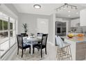 Bright dining area with a round table, and a stylish open-concept view into the modern kitchen with stainless steel appliances at 10218 Lola St, Tampa, FL 33612