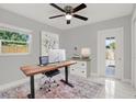 Bright office space with a modern desk, a comfortable chair, and a door to the backyard at 10218 Lola St, Tampa, FL 33612
