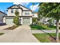 Inviting two-story townhome with a well-kept lawn, two-car garage, and appealing architectural details at 11443 Cay Spruce Way, San Antonio, FL 33576