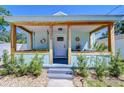 Charming front porch with wooden columns, a porch swing, and seaside-themed decorations at 1240 Georgia Ave, Dunedin, FL 34698