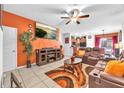 Inviting living room featuring a plush, reclining sofa, warm accent colors, and an entertainment center at 12913 Dream Catcher Way, Riverview, FL 33579