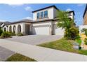 Inviting home exterior with a paved driveway leading to a three-car garage, complemented by manicured lawn at 13246 Twin Bridges Dr, Riverview, FL 33579