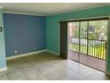 Bright living room featuring tile flooring and a sliding door to the screened lanai at 13833 Orange Sunset Dr # 201, Tampa, FL 33618