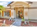 Close-up of the home's front door with decorative adornments and a well-kept landscape at 1536 Norwick Dr, Lutz, FL 33559