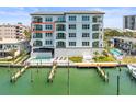 A beautiful view of the building exterior, including the pool, dock, and waterway at 211 Dolphin Pt # 403, Clearwater Beach, FL 33767