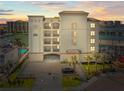Stunning exterior shot of a white building with a parking garage and waterway views at 211 Dolphin Pt # 403, Clearwater Beach, FL 33767
