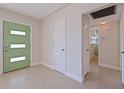 Inviting foyer with a unique green door and neutral tile flooring at 233 45Th Ave, St Pete Beach, FL 33706