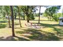 Expansive backyard featuring a fire pit and chairs, perfect for outdoor gatherings at 27477 Old Trilby Rd, Brooksville, FL 34602