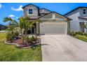 Charming two-story home featuring a well-maintained lawn, landscaped flower beds, and a two-car garage at 2870 Silver Scallop Dr, Wimauma, FL 33598