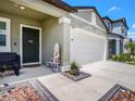 Inviting front porch with seating and decorative plants, leading to a two-car garage at 2870 Silver Scallop Dr, Wimauma, FL 33598