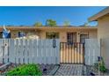 Inviting exterior featuring a private courtyard with brick pavers and white picket fence at 3135 Charter Club Dr # G, Tarpon Springs, FL 34688
