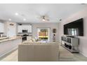 Bright living room with sliding glass doors to the patio, flowing into the kitchen area at 32648 Coldwater Creek Loop, Wesley Chapel, FL 33545