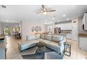Open-concept living room featuring neutral tones, recessed lighting, and easy access to the kitchen and dining area at 32648 Coldwater Creek Loop, Wesley Chapel, FL 33545