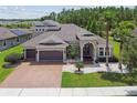 Beautifully landscaped home featuring a three-car garage, and manicured front yard with palm trees at 32791 Natural Bridge Rd, Wesley Chapel, FL 33543