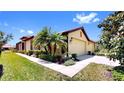 Charming single-story home with a well-manicured lawn, lush landscaping, and a two-car garage at 334 Mystic Falls Dr, Apollo Beach, FL 33572