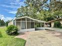 Charming home featuring a screened-in porch and covered carport, perfect for enjoying the outdoors at 34141 Tree Lake Dr, Wesley Chapel, FL 33543