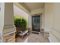 Charming front entrance with a dark door, brick accents, and a cozy bench for welcoming guests at 4194 Bexley Village Dr, Land O Lakes, FL 34638