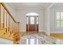 Foyer featuring marble floors, decorative front door, staircase, and wainscoting detail at 4301 W Swann Ave, Tampa, FL 33609