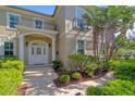 Close up of the front exterior highlighting an arched front door and professionally landscaped walkway at 4301 W Swann Ave, Tampa, FL 33609