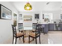 Cozy dining area with a glass table, four chairs and view to the backyard at 525 Lillian Dr, Madeira Beach, FL 33708