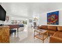 Inviting living room with a comfortable leather sofa and a beautiful view of the water at 525 Lillian Dr, Madeira Beach, FL 33708