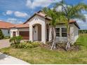 Attractive single-story home with a tile roof, well-kept lawn, and complemented by mature palm trees at 5329 Windy Grove Dr, Wimauma, FL 33598